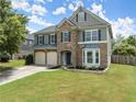 Charming two-story home featuring a stone facade, two-car garage, manicured lawn, and classic curb appeal at 5420 Stevehaven Ln, Cumming, GA 30028