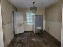 Empty dining room space with hardwood floors, neutral walls, trim detailing, and a vintage hanging light fixture at 1159 Eastridge Sw Rd, Atlanta, GA 30311