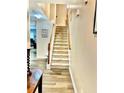 Carpeted staircase with wooden handrail and neutral walls at 2691 Pointcrest Way, Grayson, GA 30017