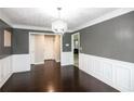 Dining area features wainscotting, crown molding, and dark hardwood floors at 620 River Mist Dr, Jonesboro, GA 30238