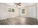 Cozy bedroom with modern gray wood-look flooring, natural light, and a ceiling fan at 114 Howell Sw Dr, Atlanta, GA 30331
