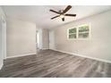 Bright living room featuring sleek wood-look flooring, ceiling fan, and ample natural light through the window at 114 Howell Sw Dr, Atlanta, GA 30331