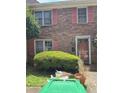 Two-story brick home with charming pink shutters and a well-maintained lawn and garden at 105 Glen Acres Ct, Decatur, GA 30035