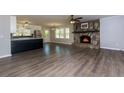 Open-concept living area featuring a stone fireplace, vinyl floors, and views of the kitchen at 216 Hickory Way, Canton, GA 30115