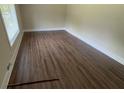 Bright bedroom featuring hardwood flooring, white trim, and a large window for ample natural light at 2292 Country Club Sw Ln, Atlanta, GA 30311