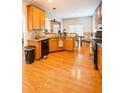 Bright kitchen with hardwood floors, wood cabinets, stainless appliances, and an adjacent dining area with natural light at 3439 Tupelo Trail, Auburn, GA 30011