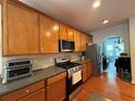 Kitchen featuring hardwood floors, wood cabinets, stainless appliances, and granite countertops at 3439 Tupelo Trail, Auburn, GA 30011
