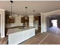 Modern kitchen with an island, pendant lighting, and stainless steel appliances at 5444 Miravista Way, Hoschton, GA 30548