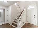 Inviting foyer featuring hardwood floors, staircase, and a bright white front door at 4252 Keheley Lake Dr, Marietta, GA 30066