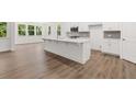 Open kitchen featuring white cabinets, stainless steel appliances, and a central island at 55 Black Rock Rdg, Sharpsburg, GA 30277