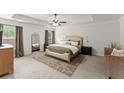 Spacious main bedroom featuring a tray ceiling, carpeted floors, and a king-sized bed with neutral decor at 5901 Cobblestone Creek Cir, Mableton, GA 30126