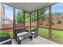 Cozy screened porch with seating, offering a view of the backyard and landscaping at 5901 Cobblestone Creek Cir, Mableton, GA 30126