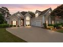 Charming two-story home with a well-manicured lawn, three-car garage, and inviting curb appeal during sunset at 9634 Coastal Pointe Dr, Villa Rica, GA 30180