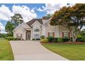 Charming two-story home with a well-manicured lawn and inviting curb appeal with mature tree at 9634 Coastal Pointe Dr, Villa Rica, GA 30180