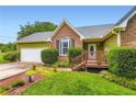 Inviting front entrance with a well-maintained lawn, colorful flower bed, and a charming covered porch at 180 Moseley Crossing Dr, Stockbridge, GA 30281