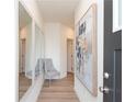 Hallway with three mirrors, gray chair, and modern artwork at 2686 Ne Almand Ne Ln, Conyers, GA 30013