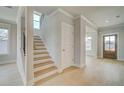 Spacious foyer featuring light wood-look floors and stairs leading to the upper level at 100 Homesite Valleyview Ct, Mcdonough, GA 30252