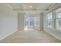Bright living room featuring tray ceiling, bay window, and wood-look flooring at 100 Homesite Valleyview Ct, Mcdonough, GA 30252