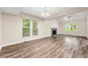Bright living room featuring a fireplace, hardwood floors and large windows overlooking the trees at 10545 Virginia Pine Ln, Alpharetta, GA 30022