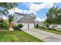 Charming two-story home with a stone accent facade, well-manicured lawn, and a long driveway at 142 Holly Mill Village Dr, Canton, GA 30114