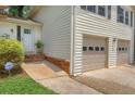 Exterior angled view of the home entrance featuring a brick pathway and two-car garage at 3196 Windfield Cir, Tucker, GA 30084