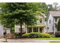 Two-story home with a welcoming front porch framed by lush bushes and a neatly kept lawn at 127 Oak Ln, Decatur, GA 30030