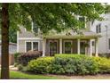 Two-story home with a welcoming front porch adorned with hanging plants and lush landscaping, blending charm and curb appeal at 127 Oak Ln, Decatur, GA 30030