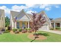 Inviting home showcasing well-maintained landscaping, a covered front porch, and an attached two-car garage at 1758 Auburn Ridge Way, Dacula, GA 30019