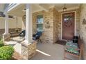Cozy covered porch with brick columns, seating area, and decorative accents creating a welcoming entrance at 1758 Auburn Ridge Way, Dacula, GA 30019