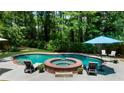 Resort-style pool area with lounge chairs, umbrellas, and a hot tub with a waterfall feature at 340 Helens Manor Dr, Lawrenceville, GA 30045
