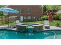 Beautiful backyard pool with spa and waterfall feature adjacent to the brick home at 340 Helens Manor Dr, Lawrenceville, GA 30045
