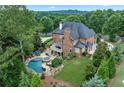 Expansive backyard with a pool, spa, waterfall feature, deck and lush landscaping, perfect for outdoor living at 7025 Windsor Hill Psge, Suwanee, GA 30024