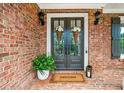 Inviting front entrance with double doors, classic brick, decorative lanterns and a 'Welcome' mat at 7025 Windsor Hill Psge, Suwanee, GA 30024