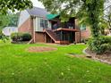Expansive backyard featuring a deck with stairs, vibrant green lawn, and mature landscaping elements at 810 Doe Hill Ln, Roswell, GA 30075