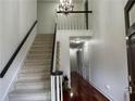 Bright entryway with staircase and hardwood floors, illuminated by a decorative chandelier at 810 Doe Hill Ln, Roswell, GA 30075