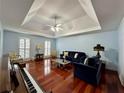 Spacious living room with tray ceiling, hardwood floors, and a comfortable seating arrangement at 810 Doe Hill Ln, Roswell, GA 30075