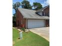 Home featuring a two-car garage with a concrete driveway and well-manicured lawn at 1165 Vineyard Ct, Stone Mountain, GA 30083