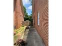 Side yard view of brick house with landscaped walkway and fencing at 1165 Vineyard Ct, Stone Mountain, GA 30083