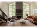 Bright living room with a stone fireplace, leather furniture, and large picturesque windows at 1282 Shiloh Trail E, Kennesaw, GA 30144