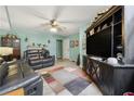 Comfortable living room with a ceiling fan, laminate floors, and a large entertainment center at 3620 Darwin Pl, Duluth, GA 30096