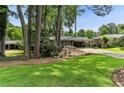 Charming brick home with a long driveway, a carport, and a lush front yard with mature trees at 1263 Blueberry Trl, Decatur, GA 30033