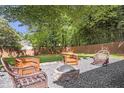 Cozy backyard firepit area surrounded by lush landscaping and mature trees at 410 Sheringham Ct, Roswell, GA 30076