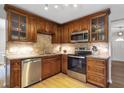 Well-lit kitchen featuring stainless steel appliances, stylish cabinetry, and a tile backsplash at 410 Sheringham Ct, Roswell, GA 30076