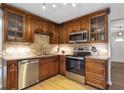 Well-lit kitchen featuring wood cabinets, stainless steel appliances, and granite countertops at 410 Sheringham Ct, Roswell, GA 30076