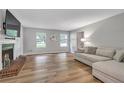Bright living room featuring a decorative fireplace, large windows and hardwood floors at 410 Sheringham Ct, Roswell, GA 30076