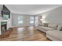 Bright living room featuring hardwood floors, a fireplace, and large windows at 410 Sheringham Ct, Roswell, GA 30076