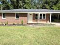 Attractive brick home with a covered carport, new landscaping and a freshly painted white front door at 882 Campbell Rd, Covington, GA 30014