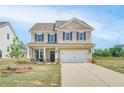 Charming two-story home with a manicured lawn and attached two-car garage at 568 Teversham Dr, Mcdonough, GA 30253