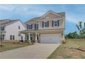 Well-maintained two-story home with an attached two-car garage and green lawn at 568 Teversham Dr, Mcdonough, GA 30253