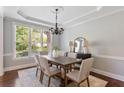 Elegant dining room with wainscoting, chandelier, and large window offering natural light at 5007 Highland Oaks Se Ct, Smyrna, GA 30126